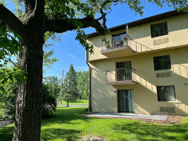 3965 Karl Rd Unit 200, Columbus, OH 43224 - rear view of property with a balcony, stucco siding, a lawn, and a patio