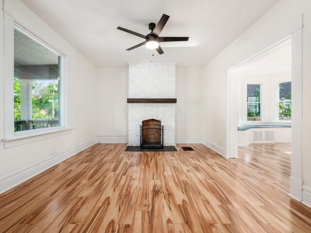 534 Berkeley Rd, Columbus, OH 43205 - unfurnished living room with light wood finished floors, a stone fireplace, baseboards, and ceiling fan