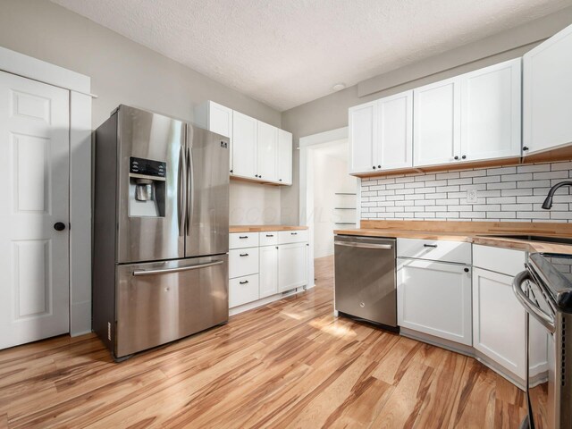 534 Berkeley Rd, Columbus, OH 43205 - kitchen with stainless steel appliances, butcher block countertops, a sink, light wood-style flooring, and a textured ceiling