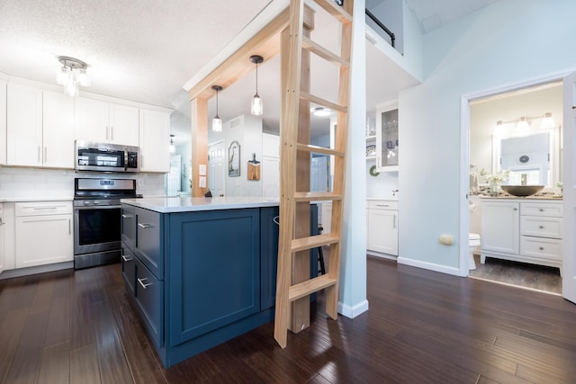 11177 Sassafrass Rd, Lakeview, OH 43331 - kitchen featuring appliances with stainless steel finishes, light countertops, white cabinetry, tasteful backsplash, and a textured ceiling