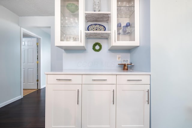 11177 Sassafrass Rd, Lakeview, OH 43331 - bar area featuring dark wood-style floors, baseboards, and a textured ceiling