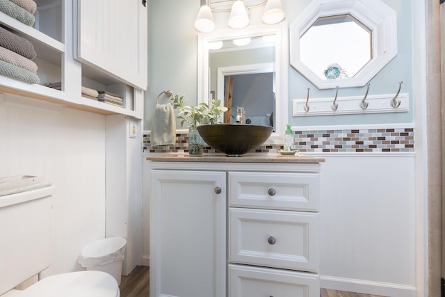 11177 Sassafrass Rd, Lakeview, OH 43331 - bathroom with vanity, toilet, wood finished floors, and decorative backsplash