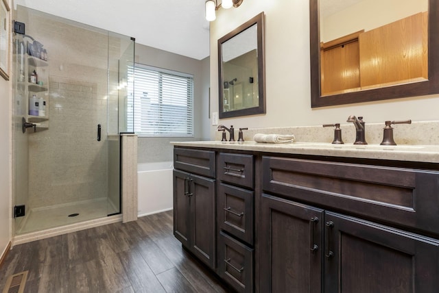 5409 Wellcrest Ct, Galloway, OH 43119 - bathroom featuring a stall shower, double vanity, wood finished floors, and a garden tub