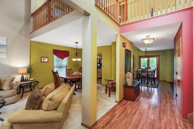 5409 Wellcrest Ct, Galloway, OH 43119 - living room featuring a chandelier, wood finished floors, baseboards, and a high ceiling