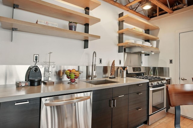 956 N High St Unit 2W, Columbus, OH 43201 - kitchen with appliances with stainless steel finishes, open shelves, light wood finished floors, light countertops, and modern cabinets
