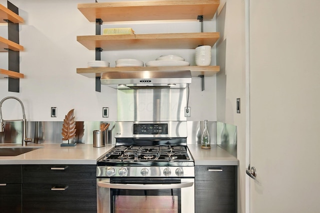 956 N High St Unit 2W, Columbus, OH 43201 - kitchen with open shelves, stainless steel gas range, extractor fan, dark cabinets, and light countertops