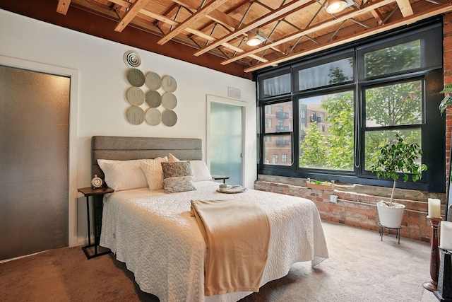 956 N High St Unit 2W, Columbus, OH 43201 - carpeted bedroom featuring brick wall