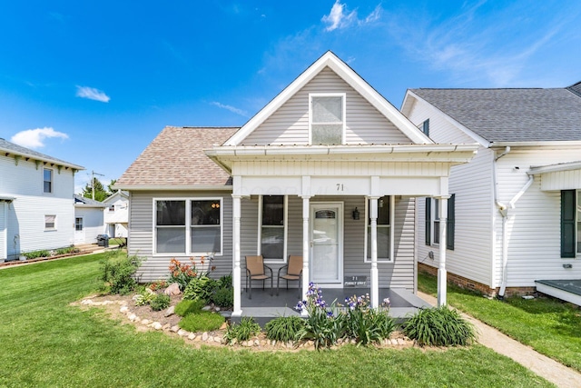 71 Market St, Carroll, OH 43112 - view of front of property with covered porch, a front yard, and a shingled roof