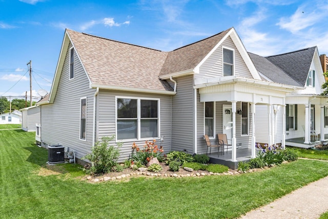 71 Market St, Carroll, OH 43112 - view of front of property with covered porch, central air condition unit, a front lawn, and a shingled roof