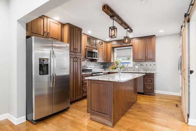 71 Market St, Carroll, OH 43112 - kitchen with appliances with stainless steel finishes, a barn door, tasteful backsplash, baseboards, and light stone counters