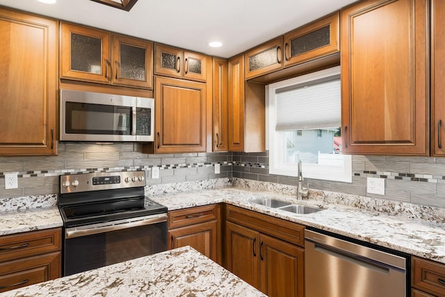 71 Market St, Carroll, OH 43112 - kitchen featuring appliances with stainless steel finishes, a sink, backsplash, brown cabinets, and recessed lighting
