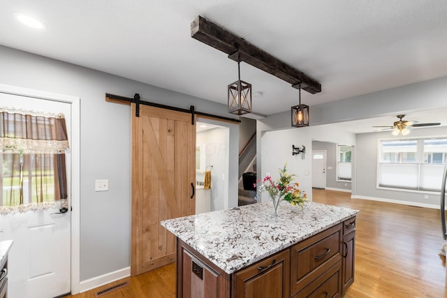 71 Market St, Carroll, OH 43112 - kitchen featuring a barn door, light wood-type flooring, ceiling fan, baseboards, and pendant lighting