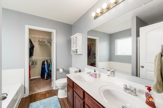 21 Mandolin Ct, Etna, OH 43062 - full bathroom featuring a bath, wood finished floors, double vanity, and a walk in closet