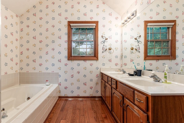 248 Academy Woods Dr, Columbus, OH 43230 - bathroom featuring lofted ceiling, wood finished floors, wallpapered walls, double vanity, and a whirlpool tub