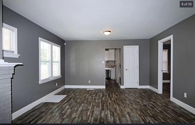 1546 E 26th Ave, Columbus, OH 43211 - unfurnished living room with dark wood-style flooring, baseboards, and a fireplace