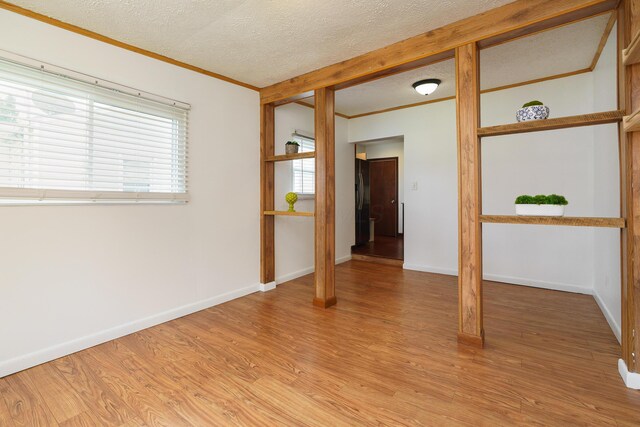 68 N Broadleigh Rd, Columbus, OH 43209 - spare room with crown molding, light wood-type flooring, and a textured ceiling