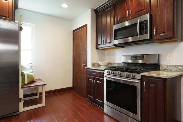 68 N Broadleigh Rd, Columbus, OH 43209 - kitchen with appliances with stainless steel finishes, dark wood finished floors, light stone countertops, recessed lighting, and dark brown cabinetry