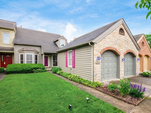 1288 Millstone Sq, Westerville, OH 43081 - view of front of house with stone siding, a garage, concrete driveway, a front lawn, and roof with shingles