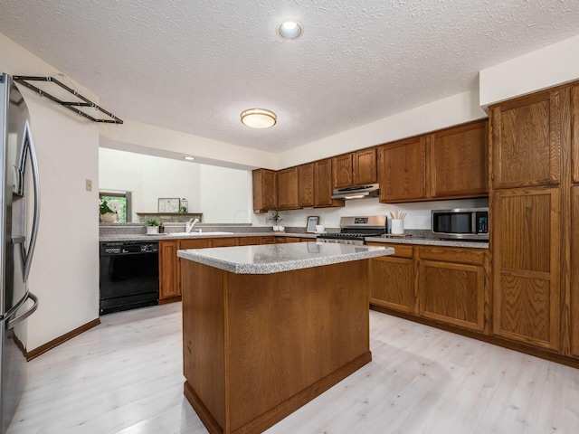1288 Millstone Sq, Westerville, OH 43081 - kitchen featuring appliances with stainless steel finishes, under cabinet range hood, light wood-style flooring, a center island, and a textured ceiling