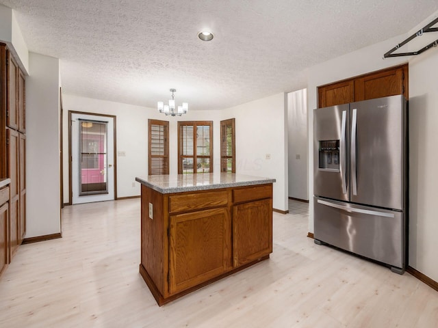 1288 Millstone Sq, Westerville, OH 43081 - kitchen featuring stainless steel fridge with ice dispenser, light wood-style floors, a chandelier, a center island, and a textured ceiling