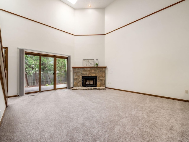 1288 Millstone Sq, Westerville, OH 43081 - unfurnished living room with carpet, a towering ceiling, baseboards, a fireplace, and a skylight