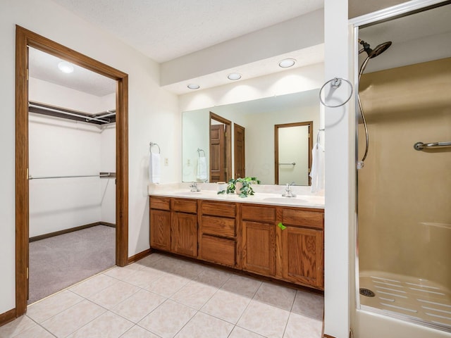 1288 Millstone Sq, Westerville, OH 43081 - bathroom with double vanity, tile patterned flooring, a shower stall, baseboards, and a walk in closet