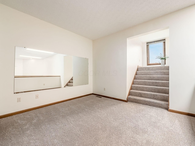 1288 Millstone Sq, Westerville, OH 43081 - empty room featuring stairway, carpet flooring, baseboards, and a textured ceiling