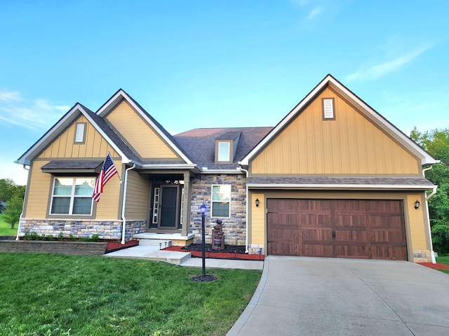 8701 Creekwood Pl, Canal Winchester, OH 43110 - craftsman-style house with stone siding, a front yard, concrete driveway, and an attached garage