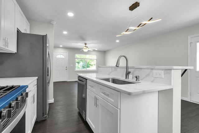 2751 Baker Ave, Cincinnati, OH 45211 - kitchen with a sink, stainless steel appliances, dark wood-style flooring, an island with sink, and white cabinetry