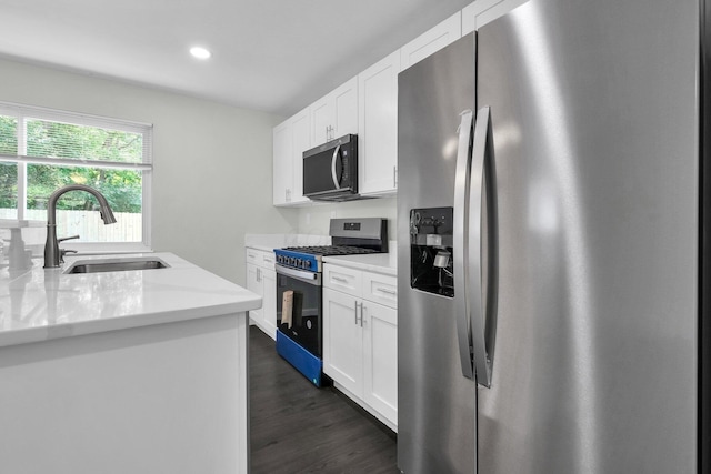 2751 Baker Ave, Cincinnati, OH 45211 - kitchen with appliances with stainless steel finishes, a sink, white cabinetry, dark wood-type flooring, and recessed lighting