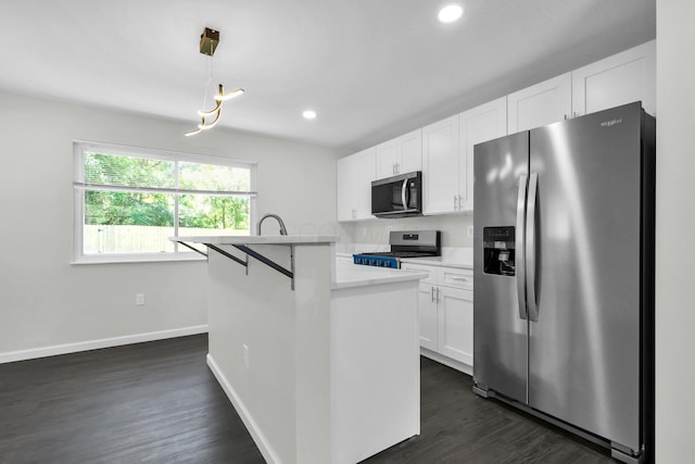2751 Baker Ave, Cincinnati, OH 45211 - kitchen with appliances with stainless steel finishes, baseboards, white cabinetry, dark wood finished floors, and a kitchen island with sink
