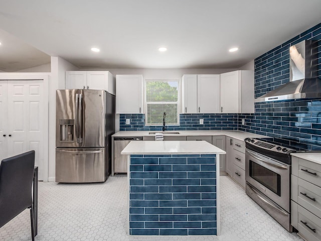 179 Boyleston Ave, Newark, OH 43055 - kitchen with stainless steel appliances, wall chimney range hood, light countertops, a kitchen island, and tasteful backsplash