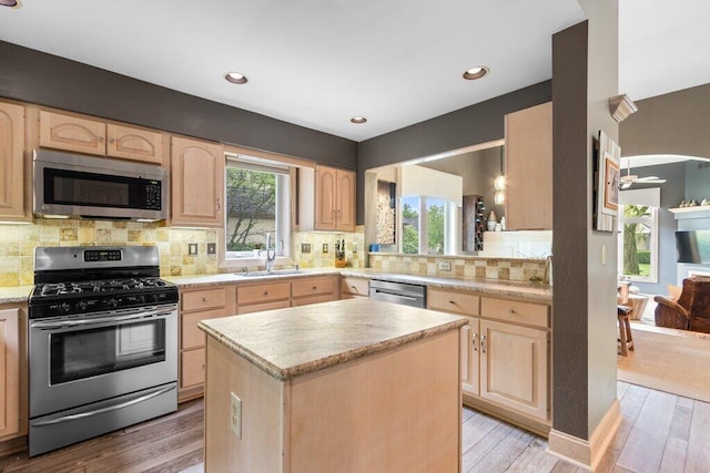 4367 Tavistock Cir, Powell, OH 43065 - kitchen featuring appliances with stainless steel finishes, light brown cabinets, a sink, light wood finished floors, and tasteful backsplash