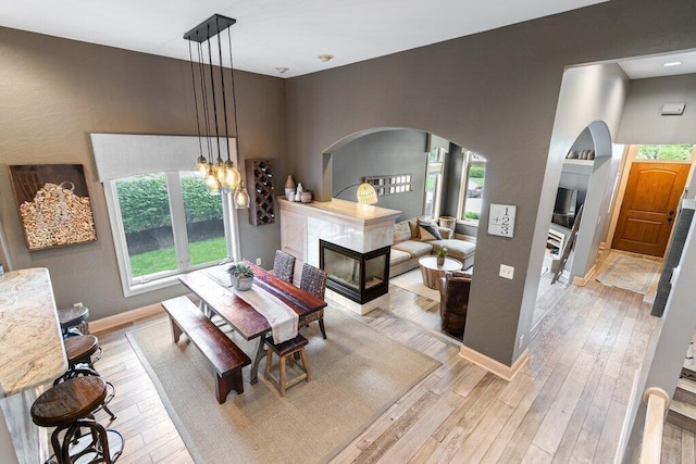 4367 Tavistock Cir, Powell, OH 43065 - dining area featuring arched walkways, light wood-style floors, and baseboards