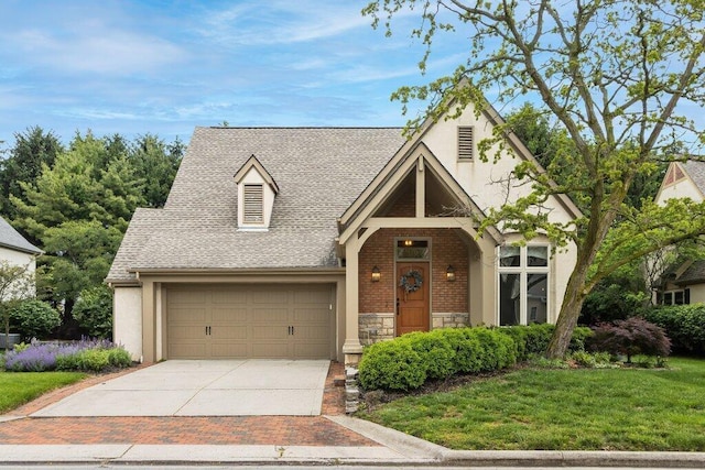 4367 Tavistock Cir, Powell, OH 43065 - tudor-style house featuring concrete driveway, a shingled roof, a garage, stone siding, and a front lawn