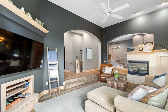 4367 Tavistock Cir, Powell, OH 43065 - living area featuring arched walkways, wood finished floors, a fireplace, and ceiling fan