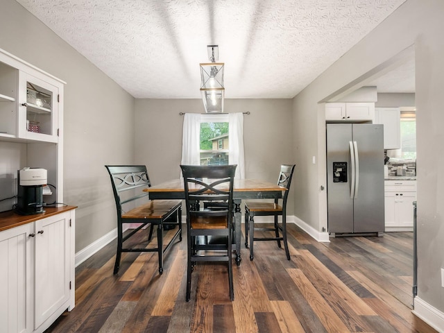 7121 Briarcliff Rd, Reynoldsburg, OH 43068 - dining area featuring dark wood-type flooring, a textured ceiling, and baseboards