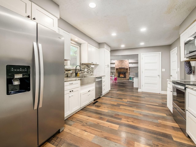 7121 Briarcliff Rd, Reynoldsburg, OH 43068 - kitchen with appliances with stainless steel finishes, dark wood-style floors, white cabinets, recessed lighting, and a textured ceiling