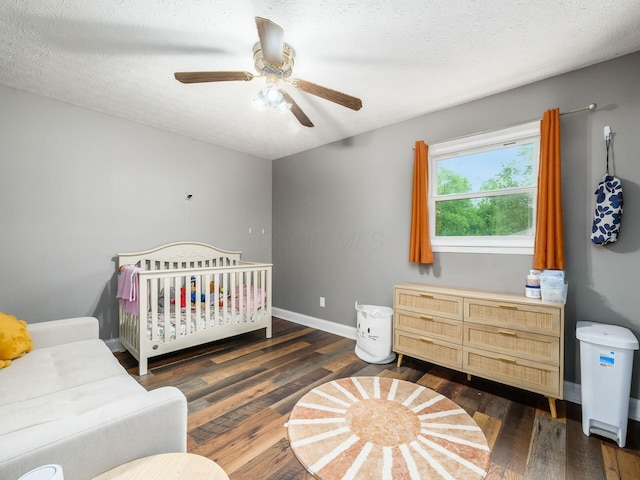 7121 Briarcliff Rd, Reynoldsburg, OH 43068 - bedroom featuring wood finished floors, baseboards, ceiling fan, a textured ceiling, and a nursery area