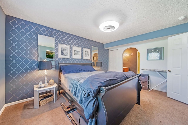 3297 Joshstock Dr Unit 3297D, Columbus, OH 43232 - carpeted bedroom with arched walkways, a textured ceiling, baseboards, and wallpapered walls