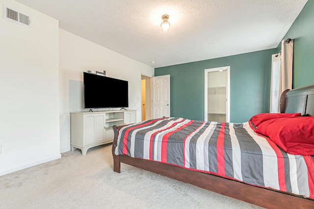 42 Carolyn Ln, Delaware, OH 43015 - bedroom with light carpet, a textured ceiling, a walk in closet, and baseboards