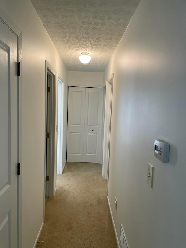 6916 Woody Ct, Canal Winchester, OH 43110 - hallway featuring light colored carpet, a textured ceiling, and baseboards