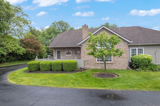 2348 Willowside Ln, Grove City, OH 43123 - view of front of house featuring a chimney, brick siding, a front yard, and roof with shingles