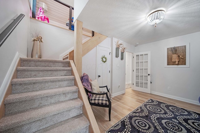 2348 Willowside Ln, Grove City, OH 43123 - stairway featuring wood finished floors, baseboards, and french doors