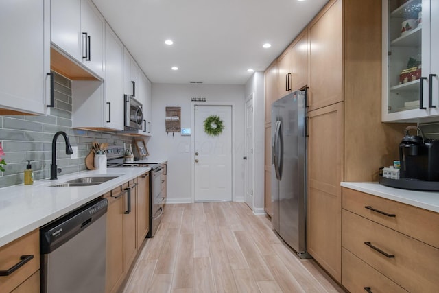 2348 Willowside Ln, Grove City, OH 43123 - kitchen with stainless steel appliances, a sink, light wood finished floors, recessed lighting, and decorative backsplash