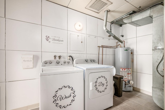 214 Arden Rd, Columbus, OH 43214 - laundry room with gas water heater, washing machine and clothes dryer, tile walls, and light tile patterned floors