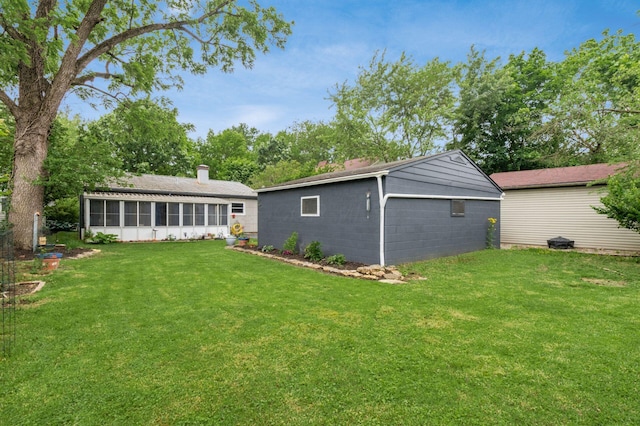 214 Arden Rd, Columbus, OH 43214 - back of house with a sunroom, a chimney, a yard, and concrete block siding