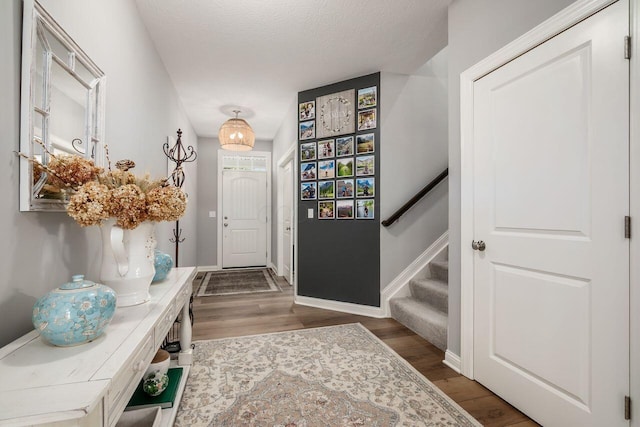 7306 Whimbrel Ln, Sunbury, OH 43074 - entryway with wood finished floors, baseboards, a textured ceiling, and stairway