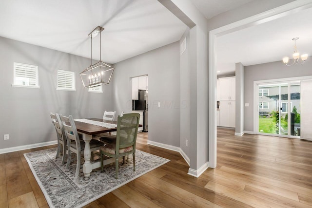 7306 Whimbrel Ln, Sunbury, OH 43074 - dining space featuring a chandelier, wood finished floors, and baseboards