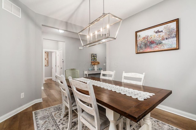 7306 Whimbrel Ln, Sunbury, OH 43074 - dining room with wood finished floors, a chandelier, and baseboards